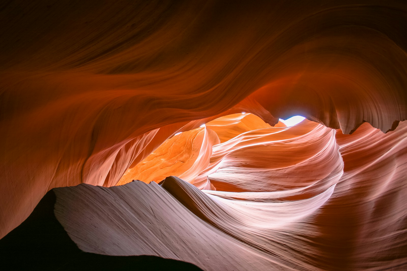 Smooth sandstone walls of a narrow canyon lit from above